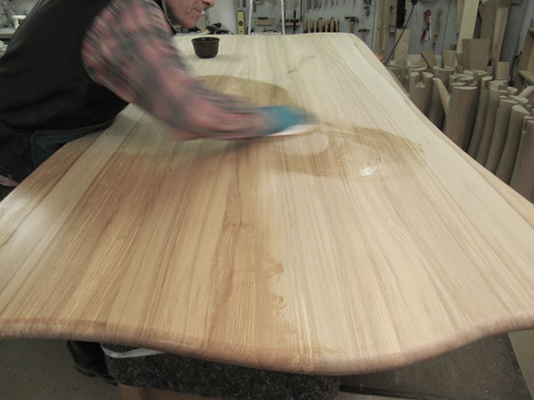 Oiling the beech dining table top with natural plant oils